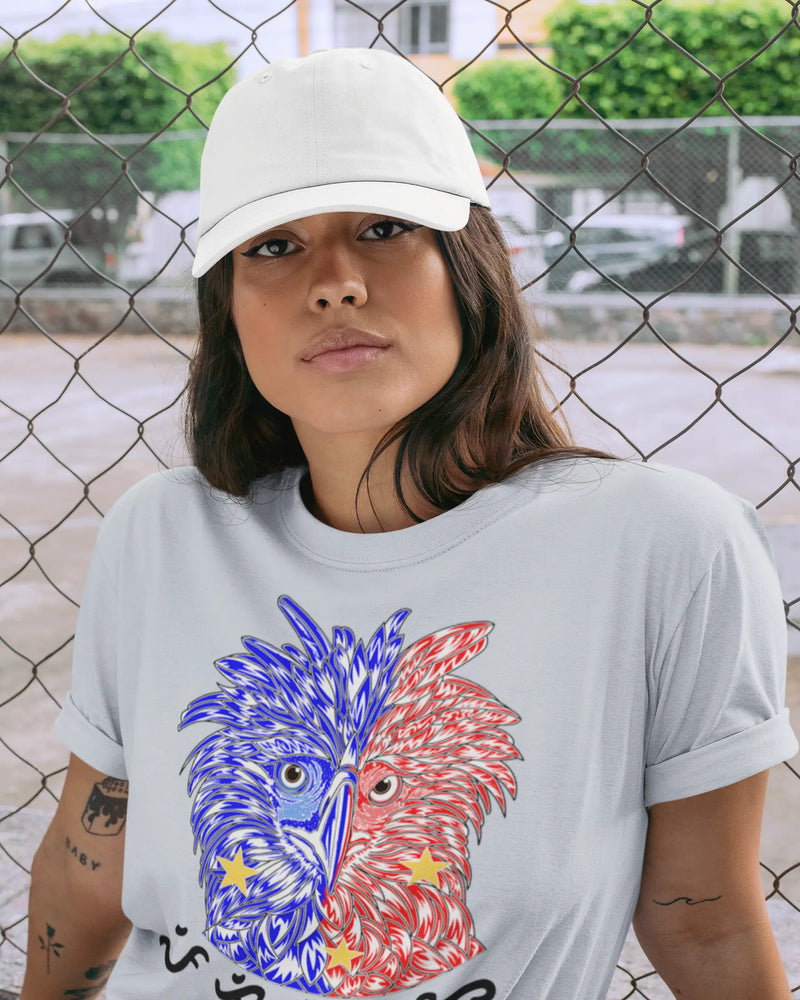 Woman in a light blue Philippine Eagle shirt with a dad hat by a chain link fence