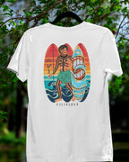 White Surfin' Siargao Badlit tee on a hanger in a nature setting