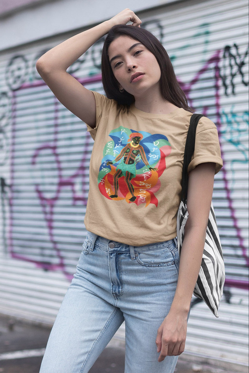 bisaya Woman wearing a beige Filipino t-shirt with a colorful graphic design showing a visayan ancient figure dancing