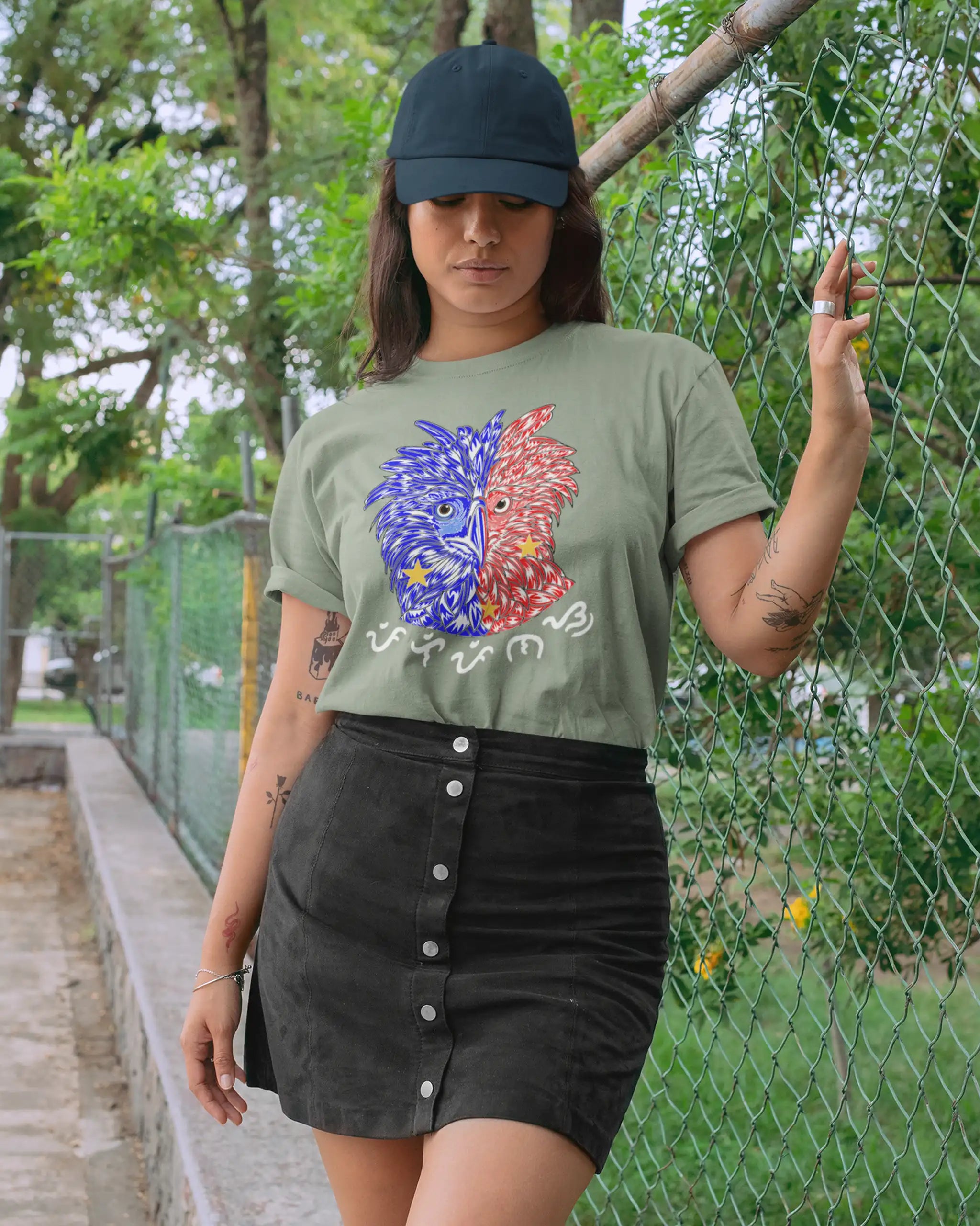 Tattooed woman wearing a sage green Filipino pride shirt, Philippine Eagle design