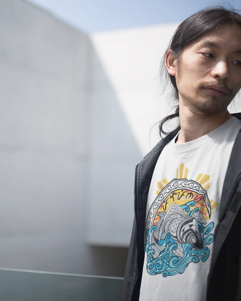 White filipino tribal art shirt with a koi and sun design, worn against a modern building.