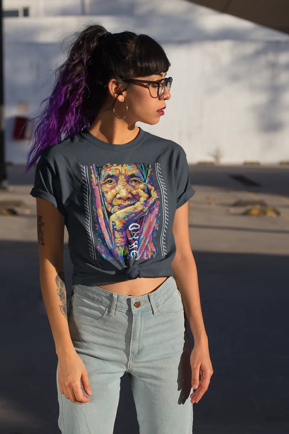Dark grey Apo Whang Od T-shirt featuring colorful Filipino batok-inspired artwork and Batikan in Baybayin worn by a Gen-Z Filipina