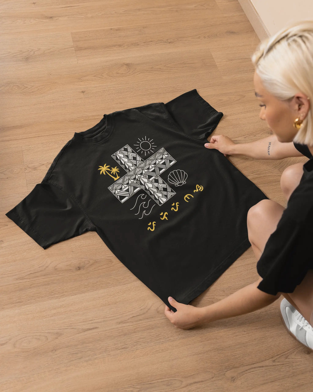 Black Pilipinas shirt laid flat, featuring the Baybayin sun and wave motif of this Filipino heritage shirt.