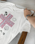 Close-up of a white Pilipinas shirt draped over a chair, highlighting the Baybayin script details.
