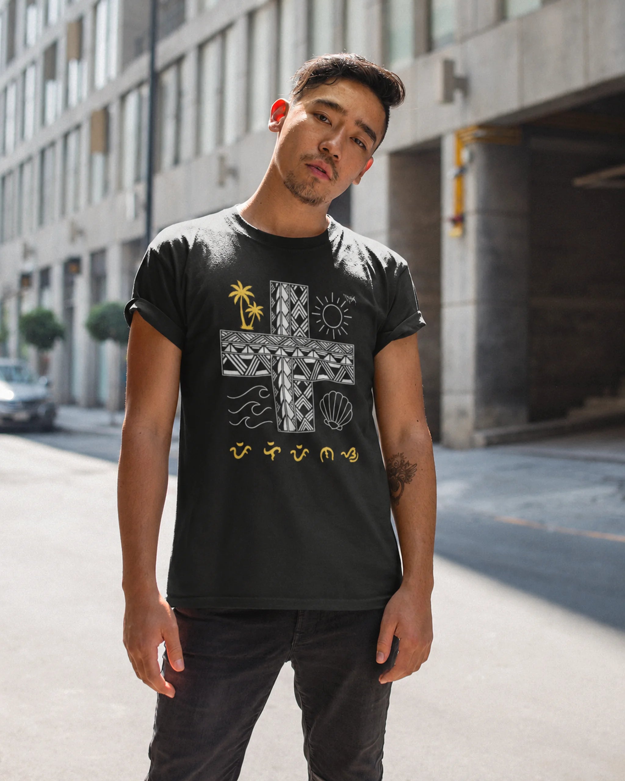 Black Pilipinas shirt worn by a man on a city street, proud Filipino heritage in Baybayin script.