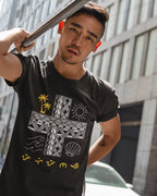 Black Baybayin shirt worn by a man against city architecture, a bold Pilipinas heritage statement.