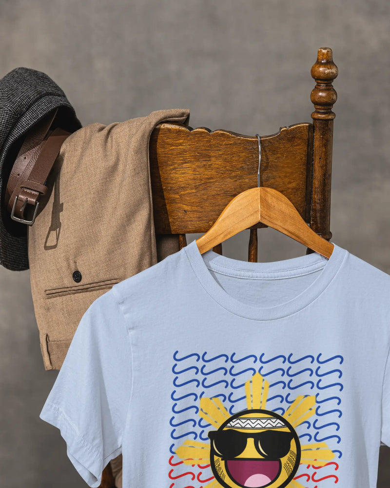 Baby blue Baybayin t-shirt on a vintage chair, close-up of the laughing sun filipino streetwear design.