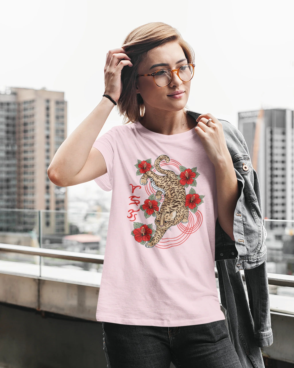 Woman against a city skyline wearing a visayan cultural shirt with Badlit leopard cat design