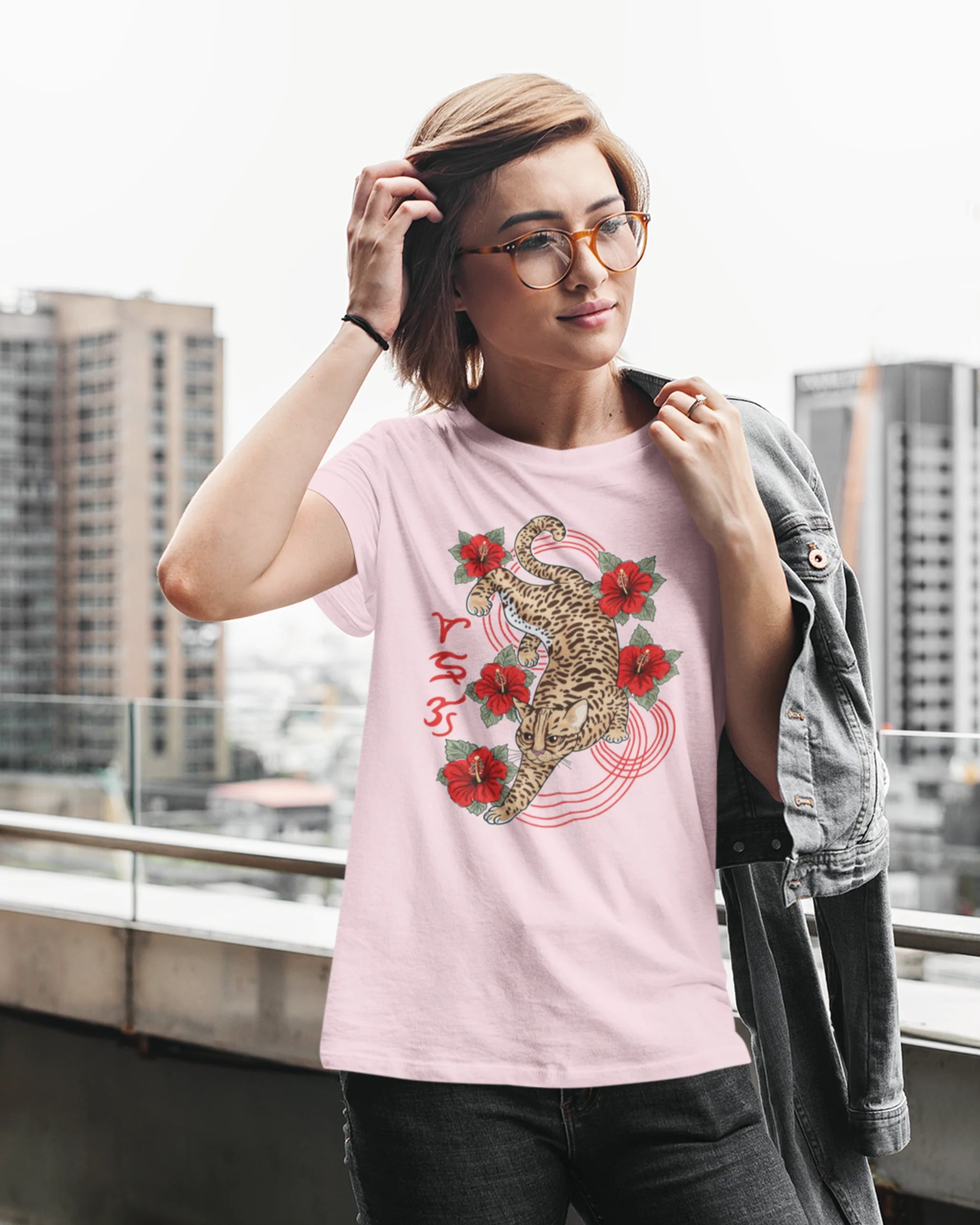 Woman against a city skyline wearing a visayan cultural shirt with Badlit leopard cat design