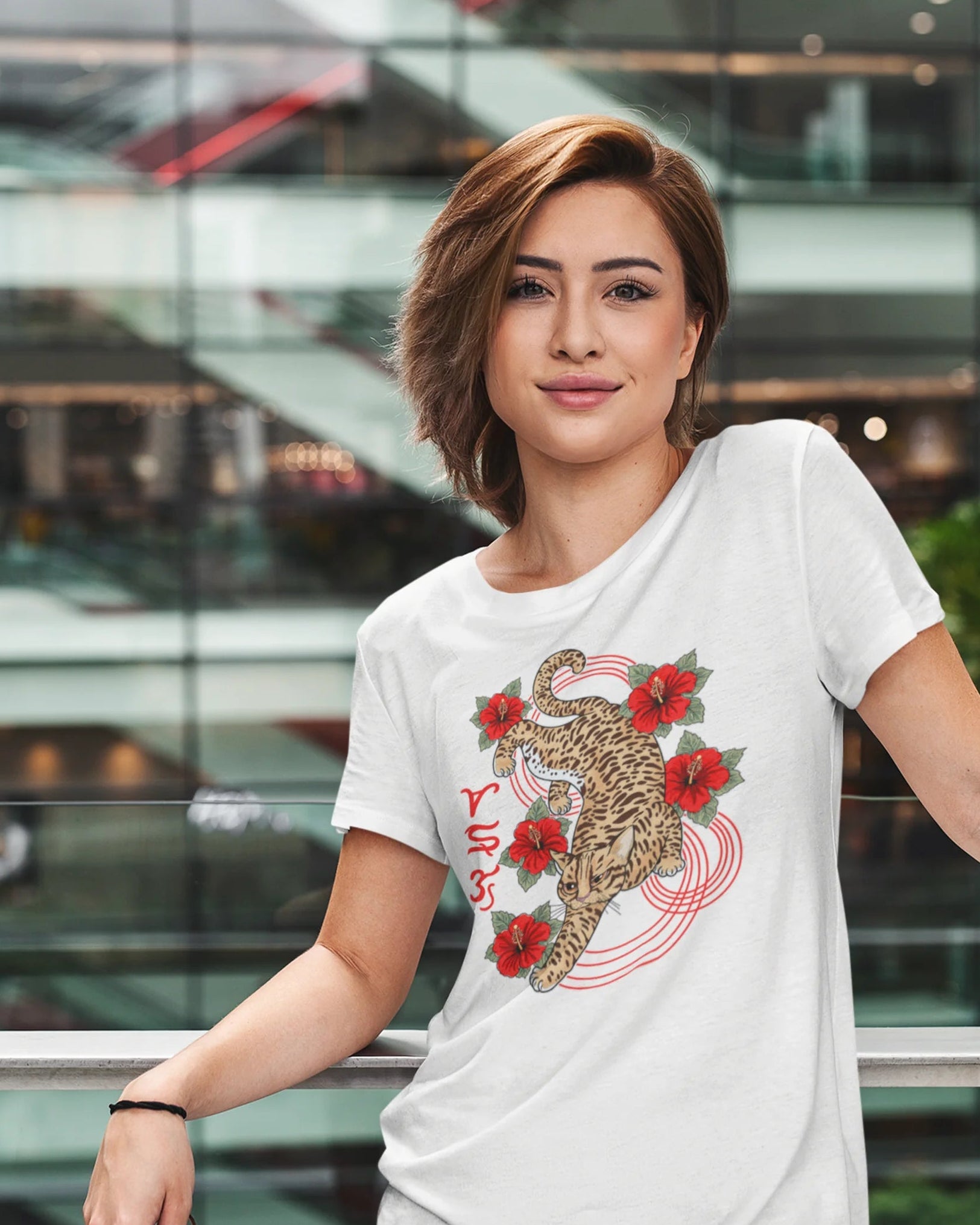 Woman wearing a Visayan cultural shirt with Badlit script and leopard cat design, city backdrop